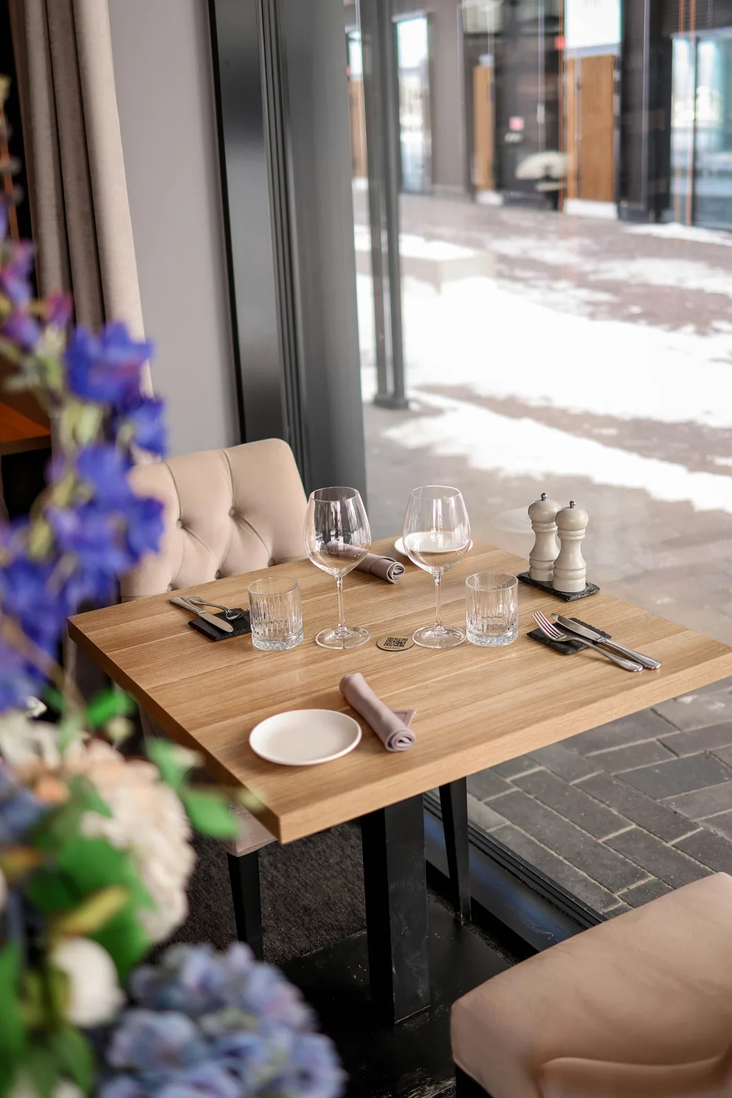 Elegant dining table set beside tall windows.